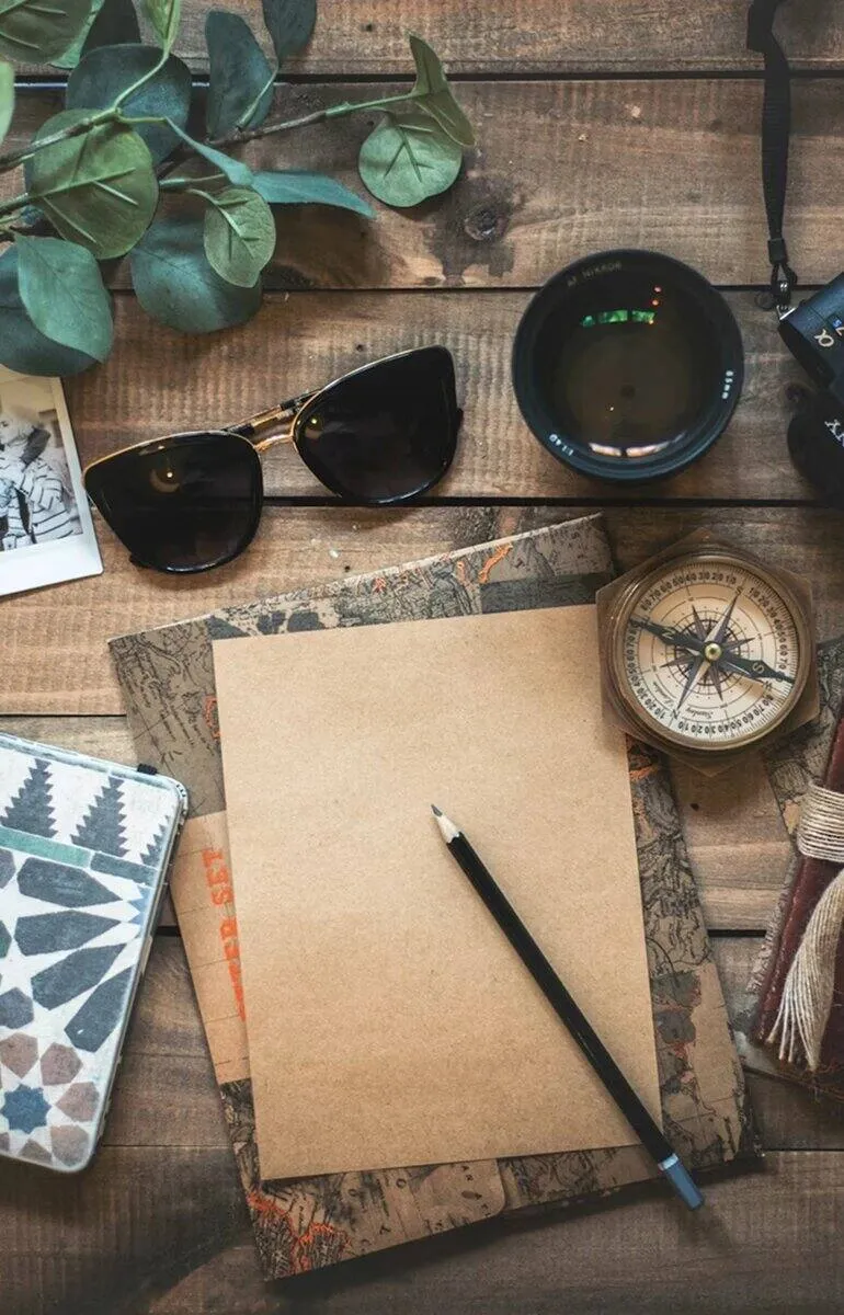 Travel flat lay with compass, notebook and camera